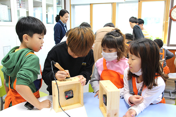 수한초 어린이들이 나무시계를 만들고 있다.