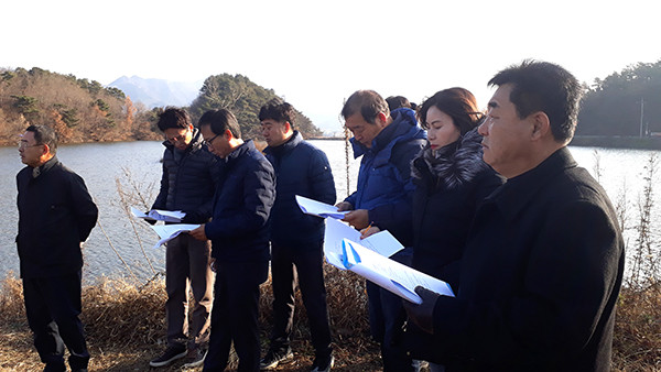 보은군의회, 행정사무감사 앞두고 현장 답사 제337회 보은군의회 제2차 정례회를 진행 중인 보은군의회 행정사무감사특별위원회(위원장 김응철)는 지난 2일 민원이 제기된 지덕저수지와 적암리 마을안길공사, 신정리 농로포장공사 3곳과 속리산 훈민정음마당을 답사했다. 지덕저수지는 보은군이 2018년 사업비 1억8900만원을 투입해 준설사업을 실시한 곳이다. 그러나 지덕저수지 부근에서 창고업을 하는 A씨가 저수지 내 중간제당을 철거한 것을 두고 ‘원상복구’를 요구하며 감사원 감사를 청구해 이목을 끌고 있다. 지덕저수지 답사를 제안한 김도화 의원은 “A씨가 도로로 사용하던 폭 2.5~3m 제당이 없어져 어려움을 받고 있다”며 “그의 입장에서 이해해보고자 현장을 방문하게 됐다”고 취지를 설명했다. 이날 답사에 동행했던 다른 의원은 “지금 상황에서 원상복구를 해주는 것은 특혜”라고 꼬집었고 또 다른 의원은 “차라리 수십억 들여 저수지를 가로지르는 다리를 놓아주겠다고 하라”고 비꼬았다. 이날 답사를 마중 나온 이 마을 이장 및 한 주민도 “저수지가 커지고 담수량이 많아졌다. 원상복구 할 필요성을 느끼지 못 한다”고 단호하게 말했다. 적암리 마을안길 공사 현장(사업비 1억2000만원)은 사유지가 다수, 여럿이 포함돼 있어 이들 간 합의가 없으면 사업을 취소할 형편이란 군 관계자의 설명이 있었다. 보은군이 2014년 확포장한 신정리 농로 공사는 “10여년전 사찰측이 길을 내며 산림을 훼손, 군이 원상복구 명령을 내렸으나 제대로 이행되지 않은 상태에서 소도로를 건설해줘 특혜 소지가 있다”고 김도화 의원은 주장했다. 국도비를 끌어들여 속리산 정이품송 맞은편에 조성한 훈민정음공원에 들어간 돈은 모두 55억원. 그럼에도 군은 추가로 군비 21억여원을 들여 휴게실, 관리실, 체험실 등을 짓고 있다. 오는 12월 말 준공예정인 가운데 행정사무감사에서 비판을 쏟아낼지 관심을 모으는 사업 현장이다. 사진은 지덕저수지를 방문한 군의원들이 관계 공무원의 설명을 들으며 현장을 살펴보고 있다./김인호 기자