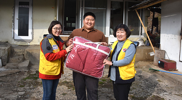 군청적십자 차현주 회장과 회원이 집수리를 해준 가정을 방문해 따뜻한 이불을 전하고 있다.