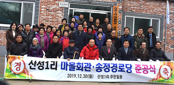 마을회관준공식을 마친 산성1리 주민과 내빈들이 이를 자축하고 있다.