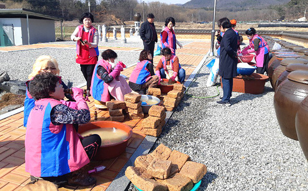 한국생활개선보은군연합회 임원들이 장안면 장내리 소재 보은군장류체험장에서 홀몸노인과 소외계층 돕기 일환으로 콩 1.5가마 분량의 메주로 장 담기를 실시하고 있다.