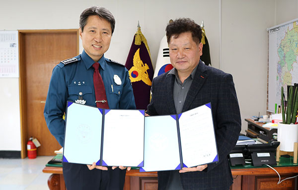 보은경찰서 김기영 서장이 보은전통시장상인회 최종호 회장과 재매결연 협약서를 교환하고 있다.