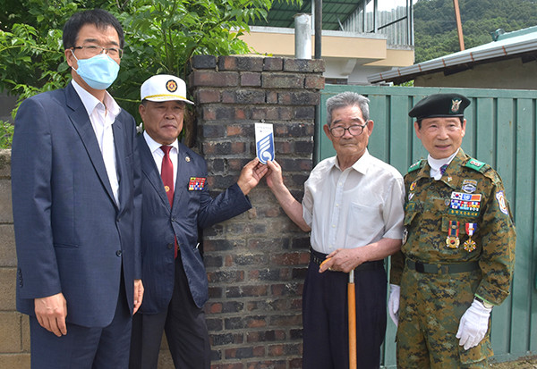 이기영 부군수와 김원빈 월남전참전자회 회장, 대한민국무공수훈자회보은군지회 이재선 회장이 권상호 참전용사의 집에 문패를 달아주고 있다.