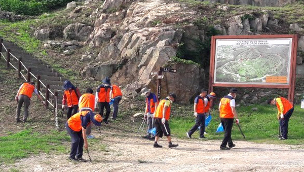 보은문화재지킴이회원들이 삼년산성입구에서 환경정화활동을 펼치고 있다.