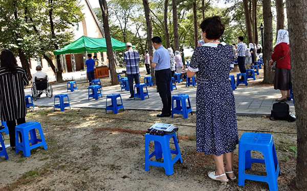 보은성당 교우들이 주일미사를 성당밖 잔디밭에서 올리고 있다.