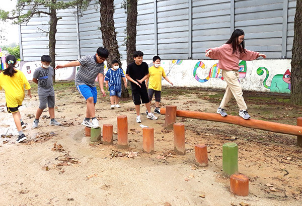 송죽초 학생들이 생태학습장에 마련된 나무징검다리를 재미있게 건너고 있다.