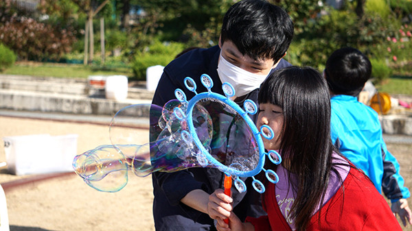 관기초학생이 버블매직쇼 강사로부터 비눗방울을 만들어 날리는 방법을 배우며 즐거워하고 있다.