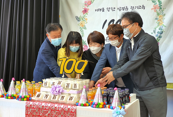 관기초 김귀숙 교장과 김가현 학생회장, 최당열 총동문회장과 동문이 개교 100주년을 맞아 기념떡을 자르고 있다.