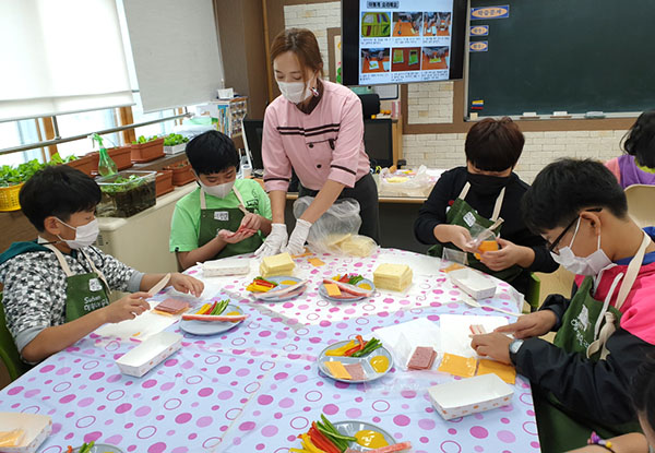 수한초학생들이 롤샌드위치를 만드는 쿠킹교실 활동을 펼치고 있다.