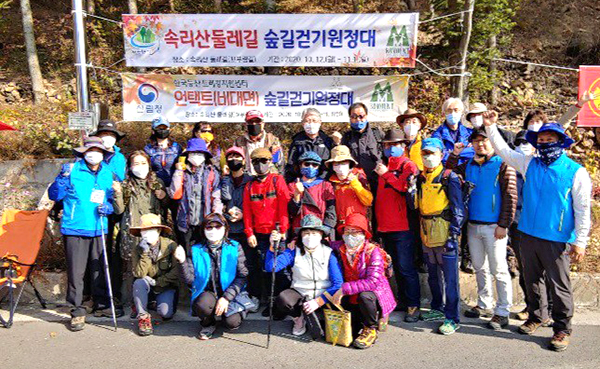 속리산둘레길 언택스 숲길걷기 현장 참여자들이 숲길생태의 아름다움을 보전한 것을 다지고 있다.