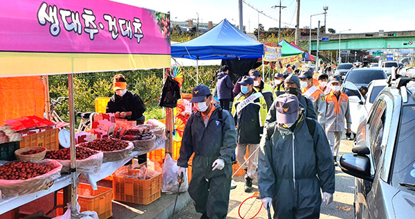 남성의용소방대 대원들이 대추판매장 일원에 대해 코로나19확산 방지를 위한 방역활동을 펼치고 있다.
