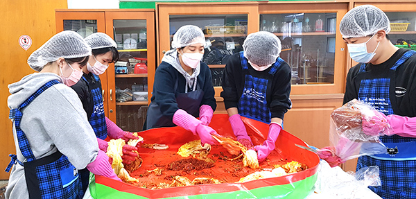 회인중학교 학생들이 좋은 배추에 넉넉한 양념을 바르며 맛있는 김장김치를 담고 있다.