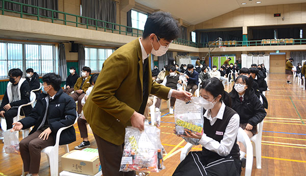 보은고 학생이 고3선배에게 선물꾸러미를 전달하며 수능을 잘 치루기를 기원하고 있다.