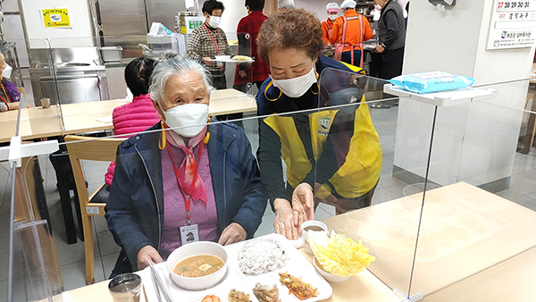 박명옥 어르신이 몸이 불편한 동료 어르신께 맛있는 밥과 반찬이 가득담긴 식판을 가져다 드리고 있다.