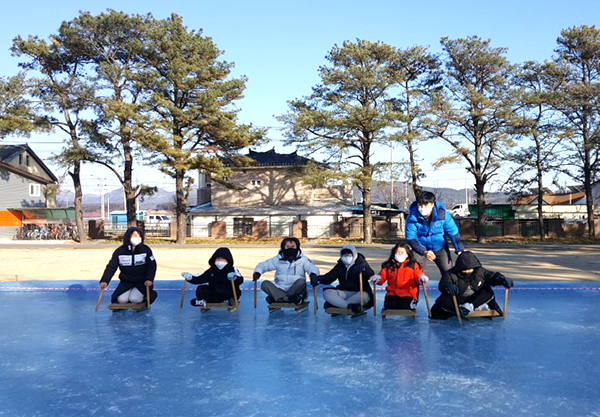 송죽초 학생들이 꽁꽁 얼어붙은 썰매장에서 썰매를 즐기고 있다.