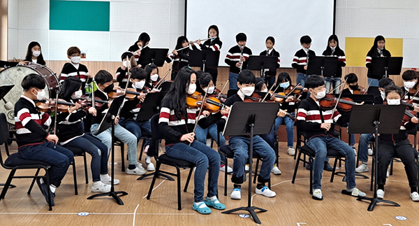수정초등학교 학생들이 꿈샘매듭의 날 행사의 일환으로 오케스트라 연주를 펼치고 있다.