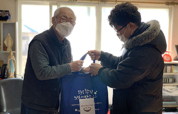 보은군노인장애인복지관 직원이 어르신께 설명절 특식을 전달하고 있다.