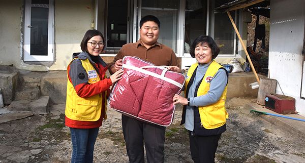 군청적십자봉사회에서 희망풍차결연세대에 이불을 전달하고 있다.