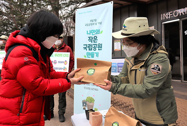 속리산국립공원사무소 직원이 속리산을 찾은 속리산 탐방객에게 ‘탄소중립다육키트’를 전달하고 있다.