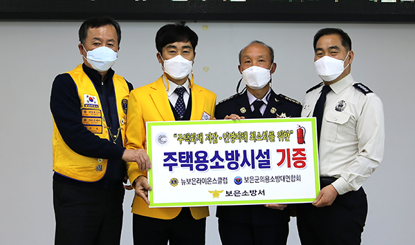곽종근(중앙왼쪽) 뉴보은라온스클럽 회장이 김형태(중앙 오른쪽) 보은의용소방대연합회장에게 주택용소방시설을 전달하고 있다.