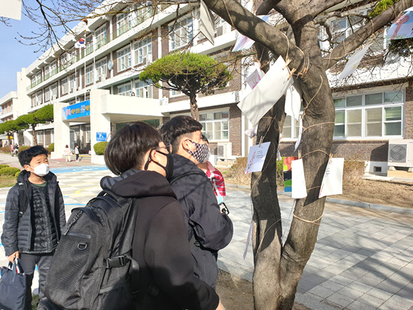 삼산초 학생들이 ‘봄꽃놀이’의 일환으로 꽃나무에 걸어둔 시를 읽고 있다.