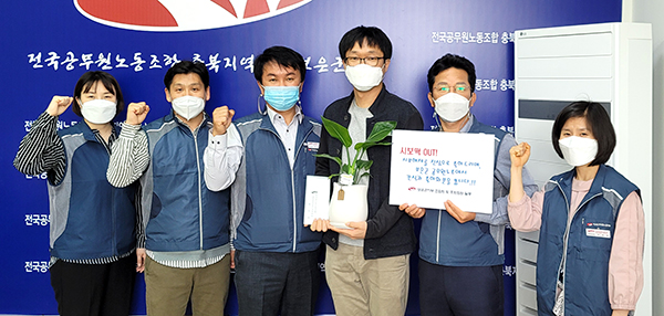 보은군 공무원노동조합 정진석 지부장(왼쪽에서 세 번째)이 행정과 신규공무원에게 화분을 전달 하고 있다.