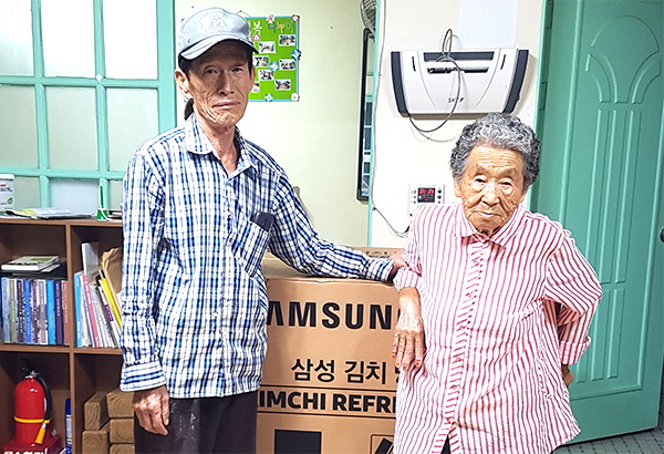 2019향수의 전통시장만들기에서 대형냉장고를 경품으로 받은 이동호 할머니가 이를 어예선 노인회장에게 기탁하고 있다.