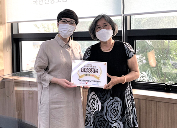 (A)은빛사랑노인복지센터에 최우수기관 선정 현판을 전하고 있다.