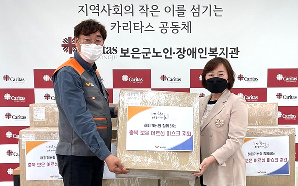 (사)해피기버홍사범 이사장이 보은군노인장애인복지관 박미선 관장에게 마스크를 후원물품으로 전달하고 있다.