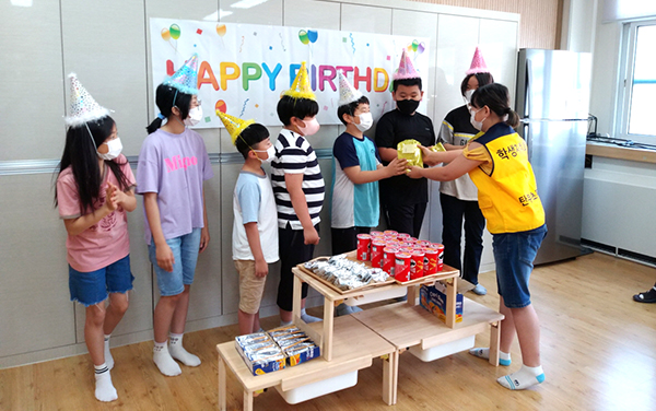 탄부초 학생자치위원이 생을 맞이한 학생들에게 축하의 고깔모자를 씌우고 선물을 전달하고 있다.