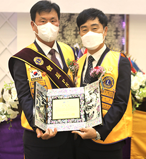 취임한 뉴보은라이온스클럽 윤병국(좌) 회장이 이임하는 곽종근 회장(우)에게 공로패를 전하고 있다.