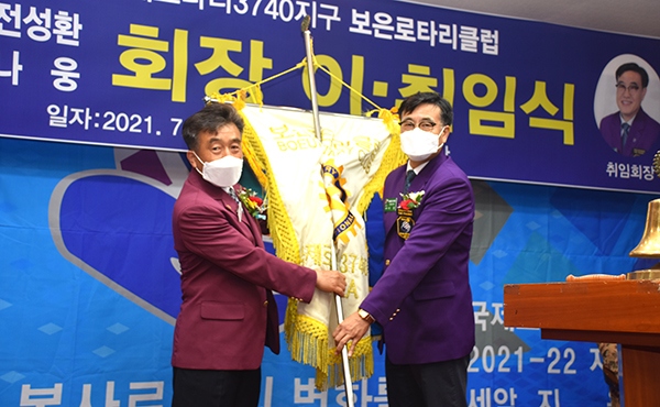 전성환 이임회장(왼쪽)이 나 웅 취임회장에게 보은로타리클럽기를 전달하고 있다.