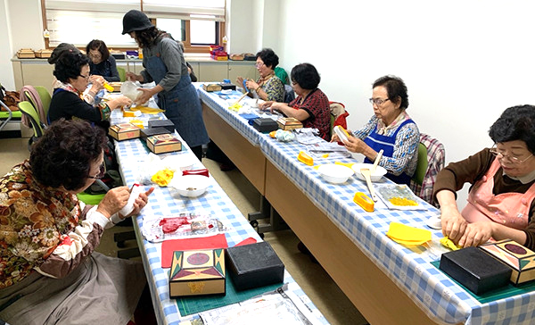 코로나가 없었던 2018년, 노인취미교실에서 노인들이 한지공예를 배우고 있다.