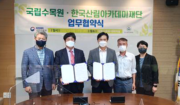 한국산림아카데미재단과 국립수목원 대표자들이 업무협약을 체결하고 실행을 약속하고 있다.