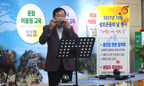 연규영 교육장이 하모니카 선율을 선사하며 출근하는 직원들을 맞이하고 있다.