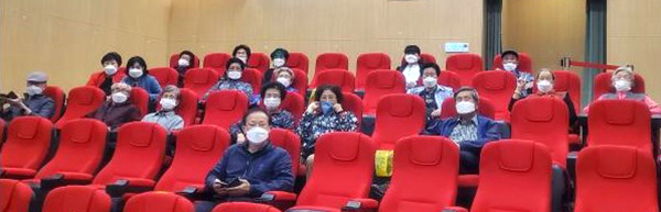 복지관 관계자들이 영화관에 들어서는 어르신들께 영화를 보며 즐길 수 있는 음식을 전달하고 있다.