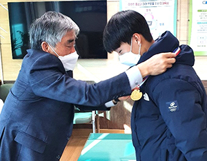 보은중학교 김희철 교장이 김현식 선수의 목에 금메달을 걸어주고 있다.