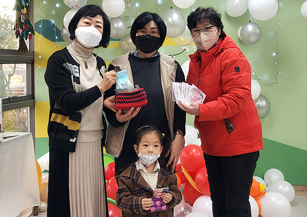 고은자 관장이 복지관을 방문한 사랑어린이집 강순옥 원장과 원아에게 비즈 팔찌·반지세트를 전달하고 있다.