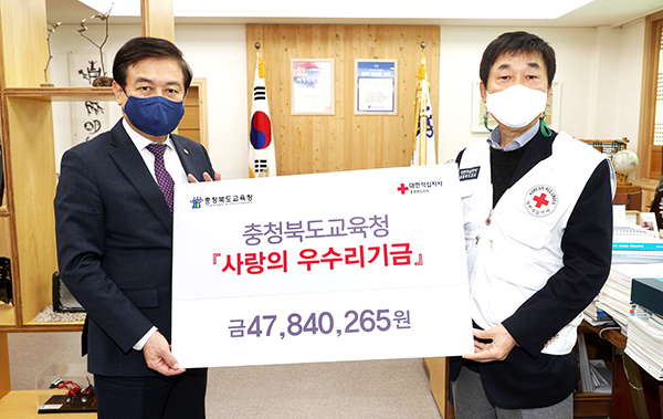 김병우 교육감이 '사랑의 우수리 운동'으로 모아진 기부금을 김경배 충북적십자사 회장에게 전달하고 있다.