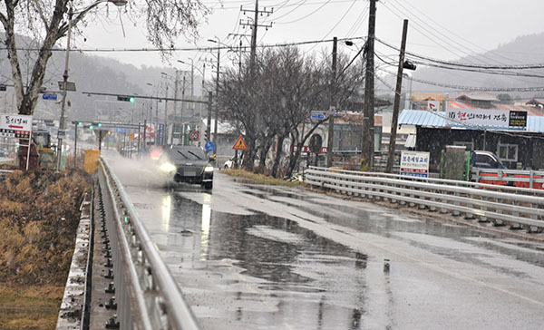 거현천 보은교에 비가 내려 고인물을 한 차량이 물을 뿜어나며 달리고 있다.