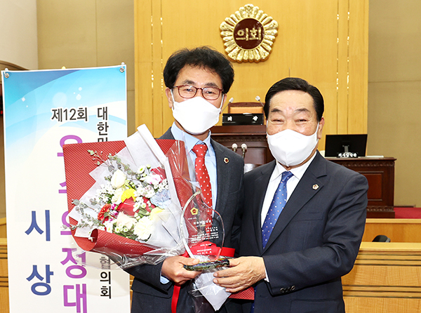 원갑희 충북도의원이 우수의정 대상 수상 후 충북도의회 박문희 의장의 축하를 받고 있다.