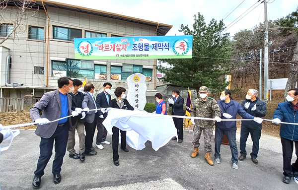 제막식에 참여한 기관단체장들이 조형물에 씌워진 천막을 걷어내고 있다.