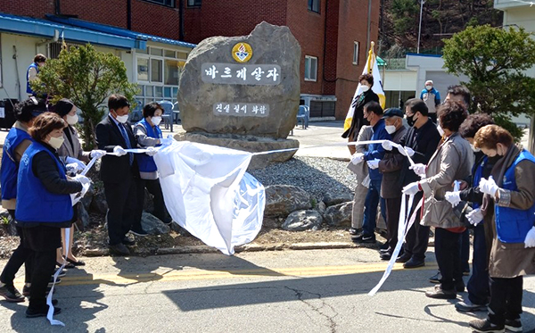 제막식에 참여한 바르게살기회원들이 조형물에 씌워진 천막을 걷어내고 있다.