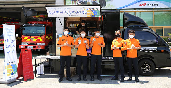 보은소방서 직원들이 사랑의 커피차에서 커피와 쿠키를 받고 만족을 표하고 있다.