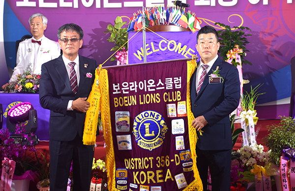 구동후 전 회장이 최국정 신임회장에게 보은라이온스클럽기를 전달하고 있다.