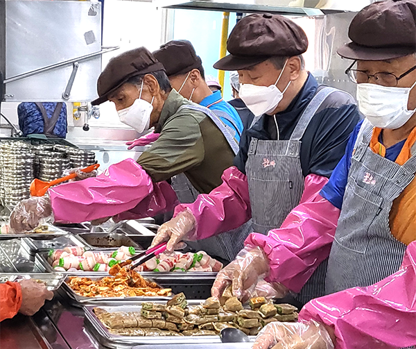 꽃오빠봉사단원들이 앞치마를 두르고 배식봉사를 하고 있다. 
