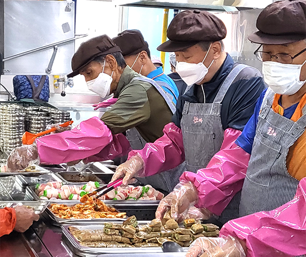 꽃오빠봉사단원들이 앞치마를 두르고 배식봉사를 하고 있다.