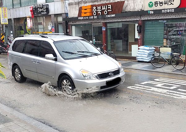 보은읍 중앙사거리로 가는 차량이 전선지중화사업공사로 고인물을 뛰기며 지나고 있다.