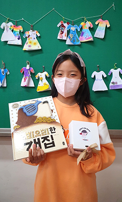동광초 학생이 책을 들어 보이며 독서에 만족감을 표하고 있다.