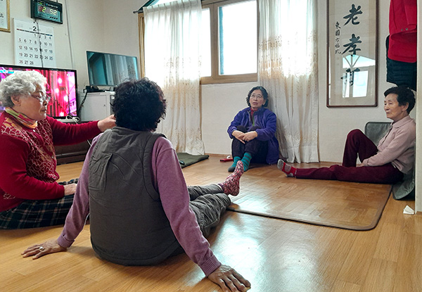 경로당에 모인 주민들이 기름값을 아끼려 전기장판을 깔고 있다.